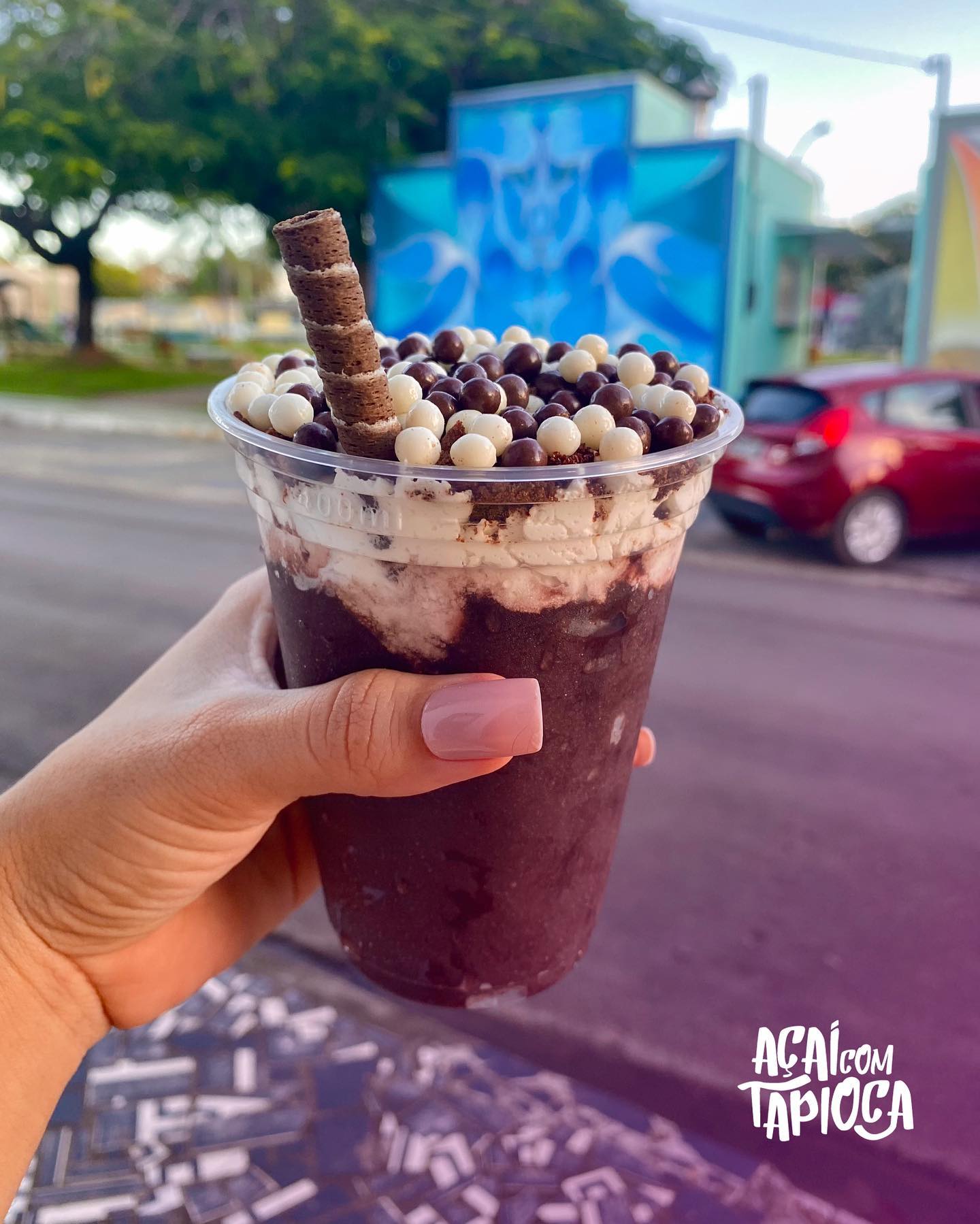 Açaí cremoso com confeitos de chocolate branco e ao leite e canudo de wafer