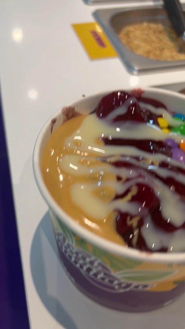 Copo de açaí com leite condensado, frutas e confetes coloridos