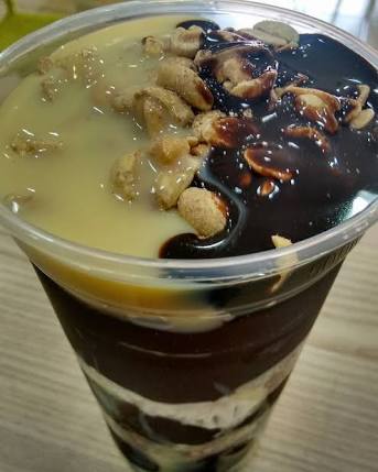 Copo de açaí com castanhas, calda e leite condensado
