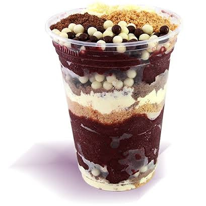 Copo de açaí em camadas com creme, granola e toppings