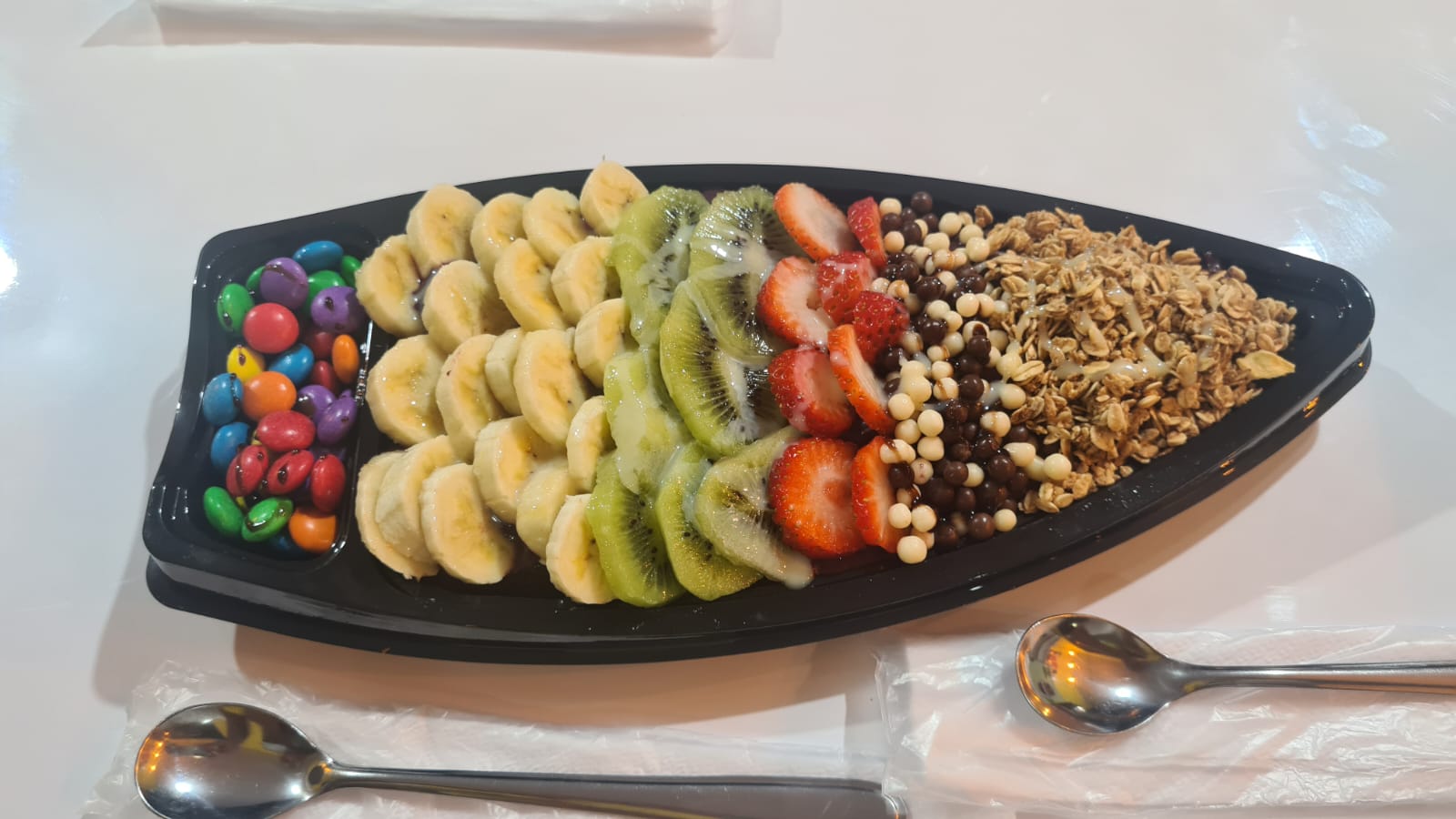 Barca de frutas com banana, kiwi, morango e granola