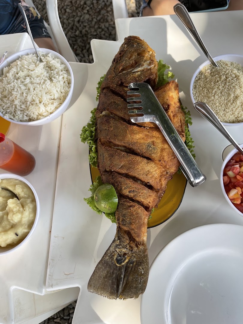 Peixe frito inteiro servido com arroz, farofa, pirão e vinagrete