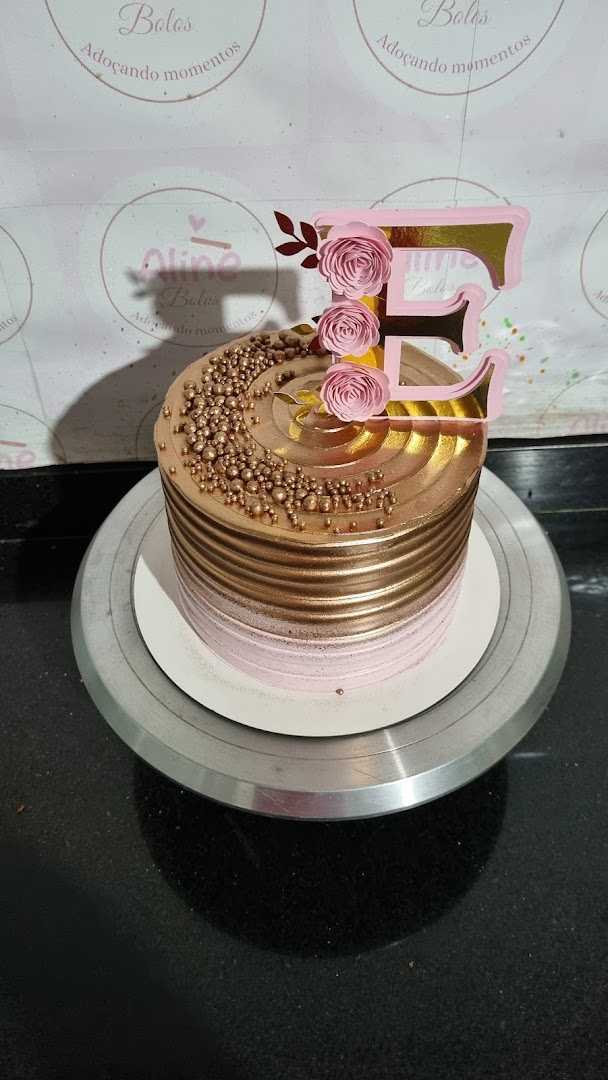 Bolo dourado e rosa em degradê com pérolas e inicial no topo