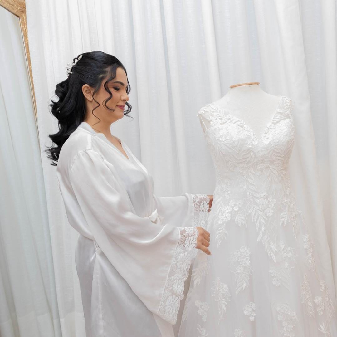 Noiva de robe ao lado do vestido