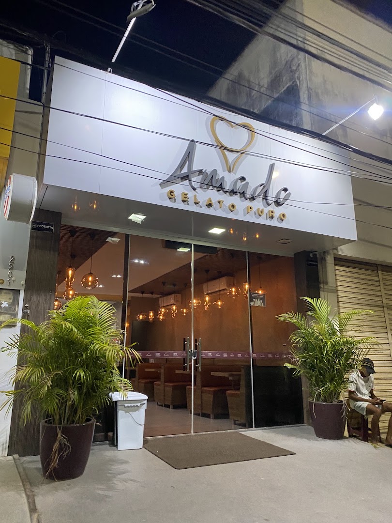 Fachada elegante da Amado Gelato Puro com plantas e luzes quentes