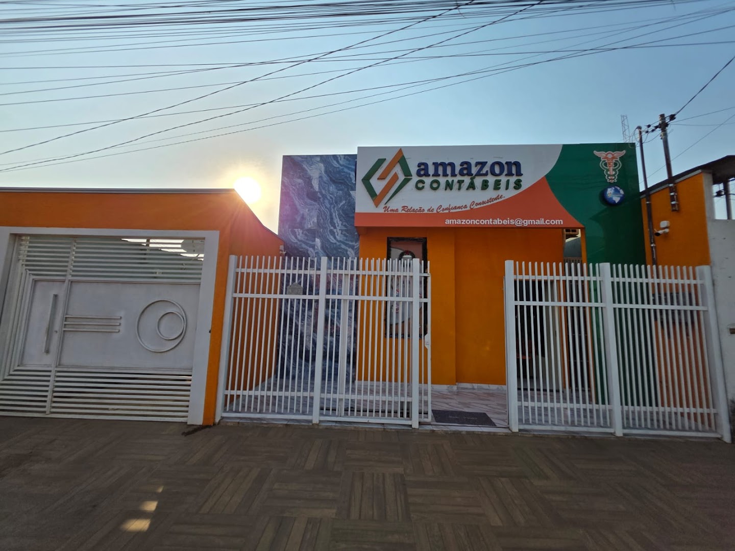 Fachada laranja da Amazon Contábeis com letreiro e portão branco, em Parauapebas
