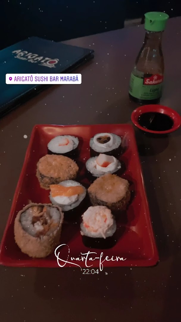 Rolinhos uramaki variados numa travessa vermelha, acompanhados de shoyu