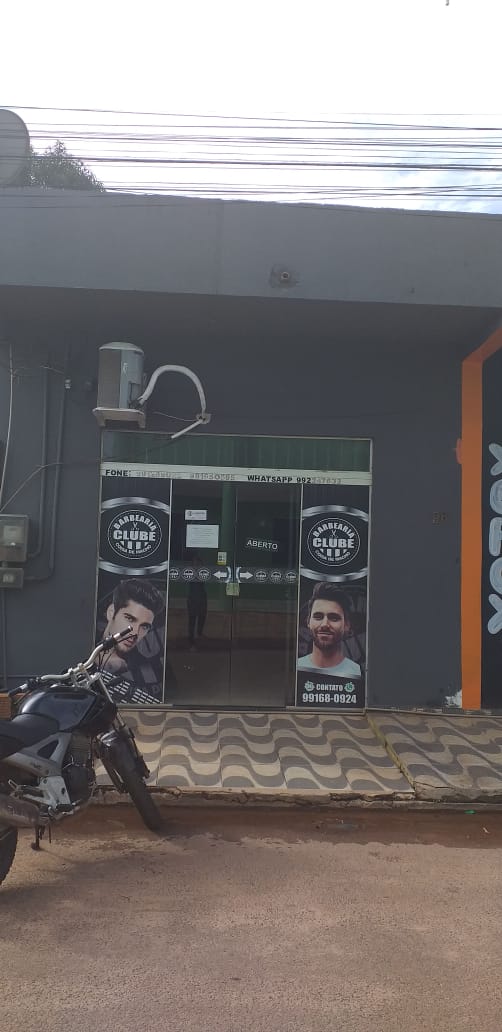 Frente da Barbearia Club com posteres de corte