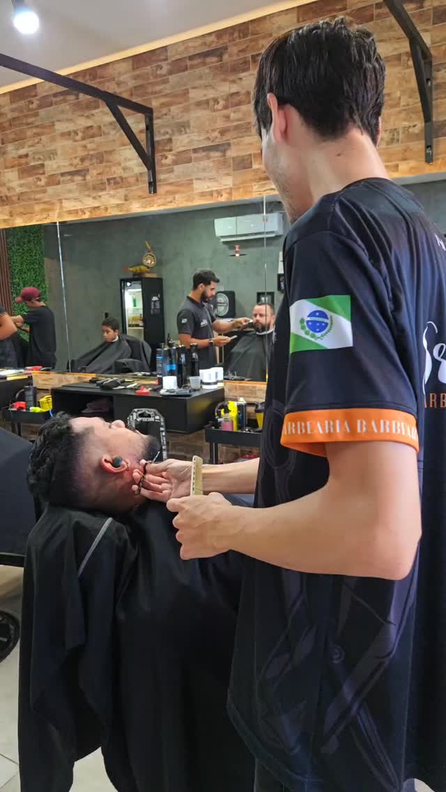 Barbeiro trabalhando a barba com navalha