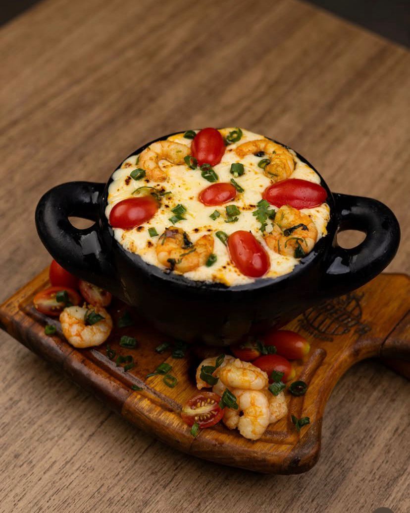 Camarão gratinado no queijo com tomatinhos, servido quente na panela