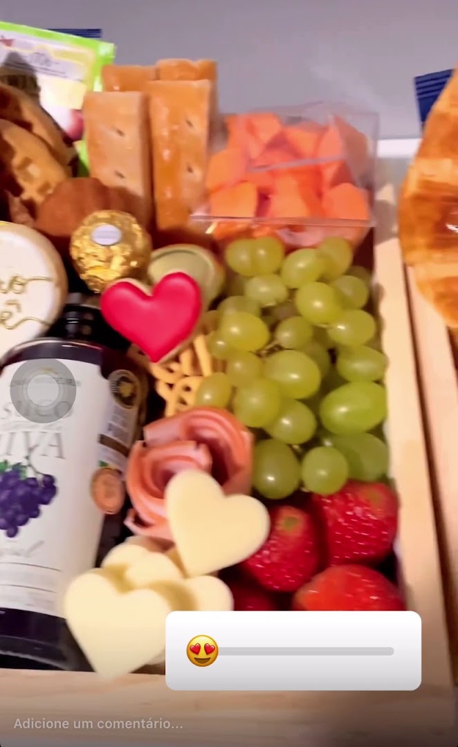 Box de café da manhã com uvas, morango, queijos em formato de coração e bebida