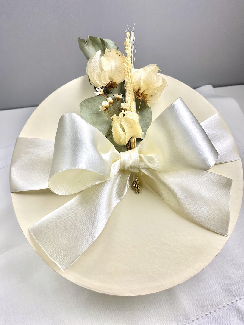 Presente creme e dourado embrulhado com laço elegante
