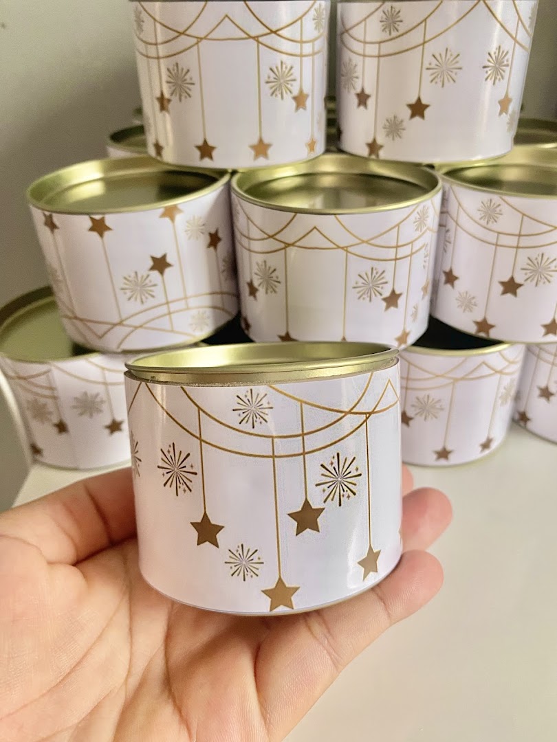 Latinhas brancas e douradas com detalhes de estrelas