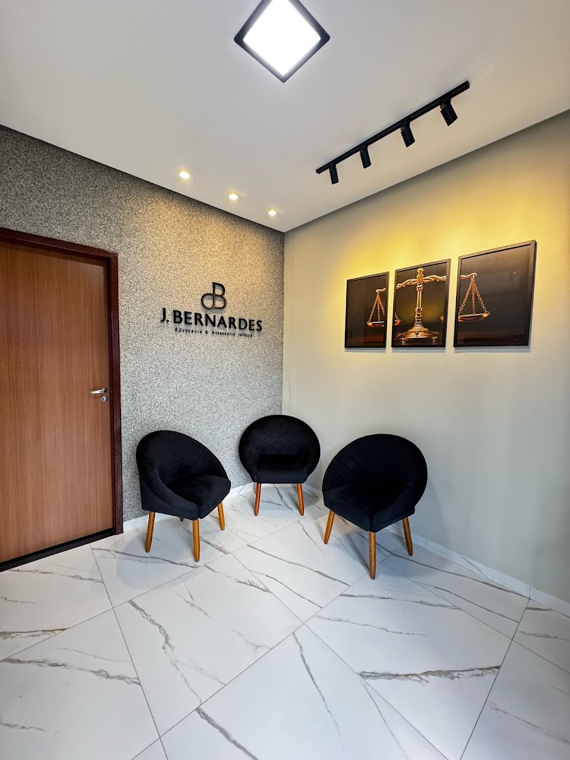 Recepção do escritório com logo na parede e quadros da balança da justiça