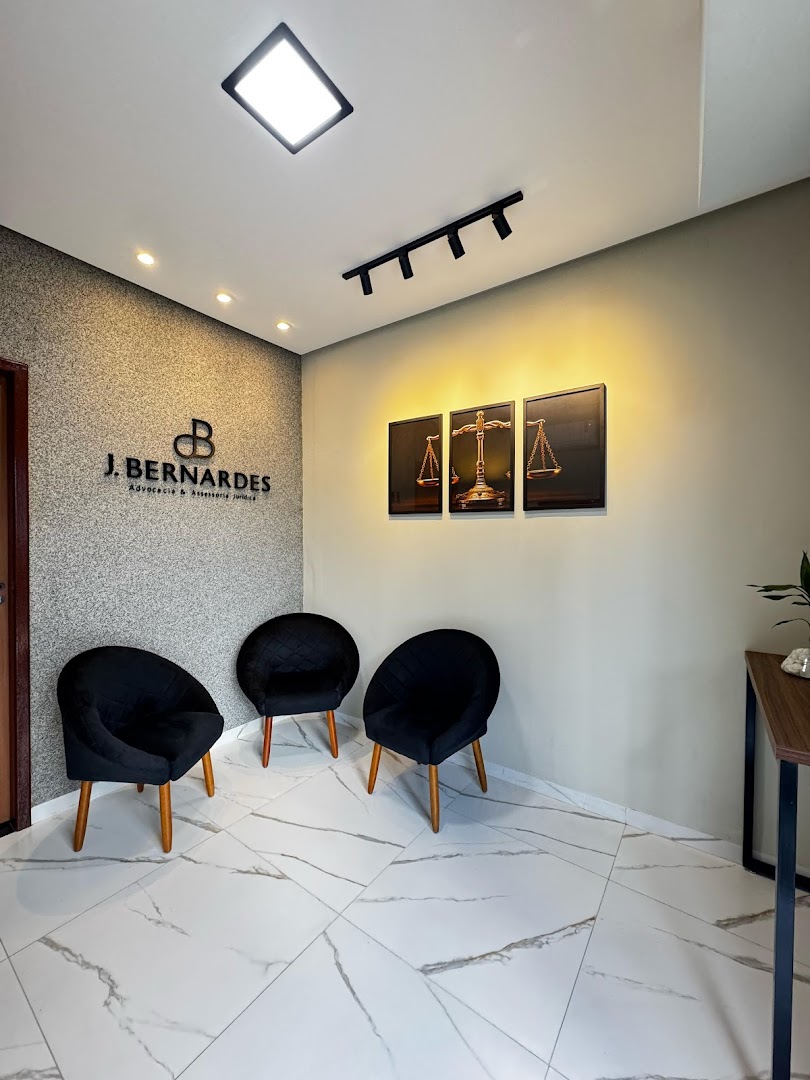 Sala de espera com poltronas pretas e quadros na parede