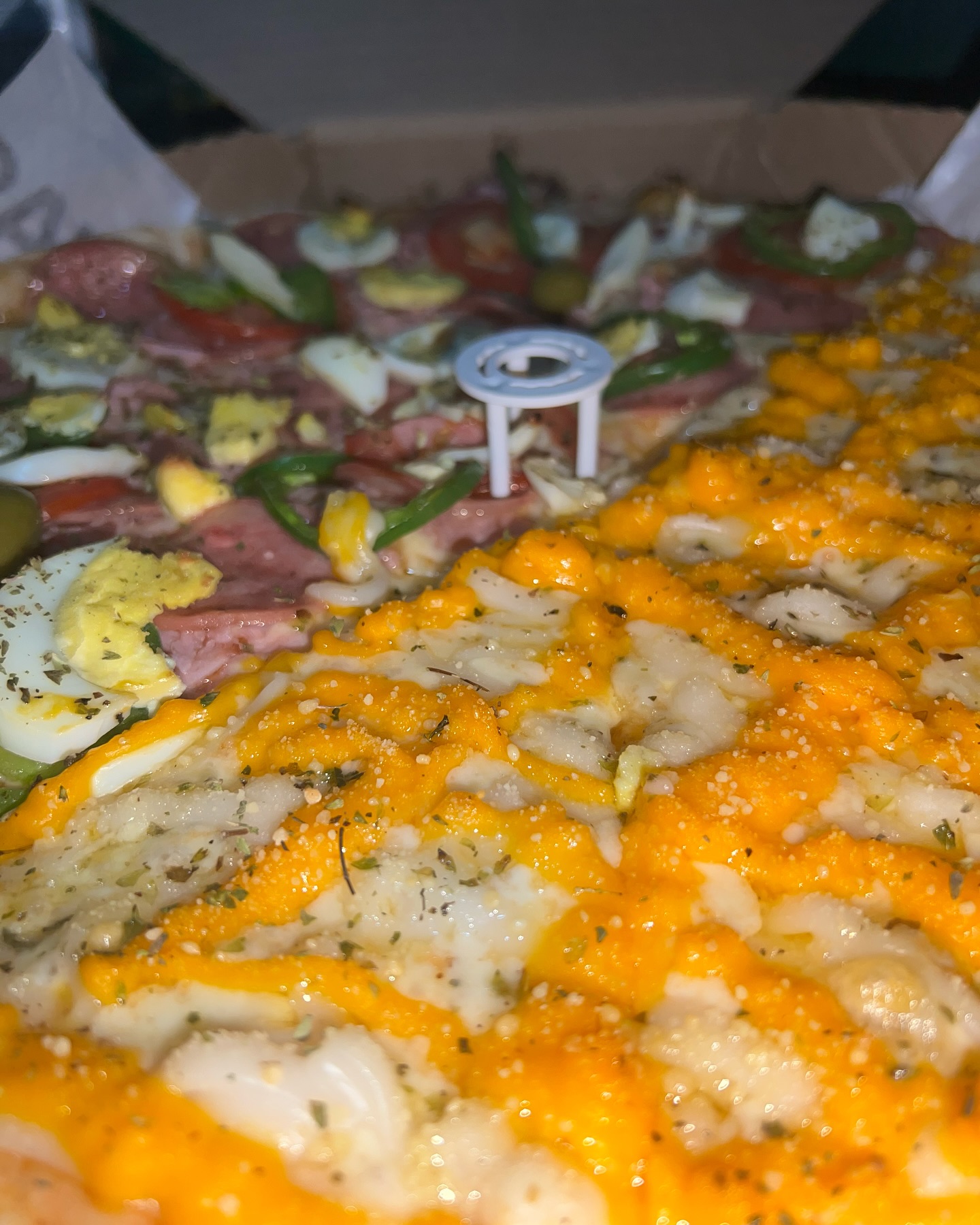 Pizza meio a meio vista de perto, calabresa de um lado e queijo do outro