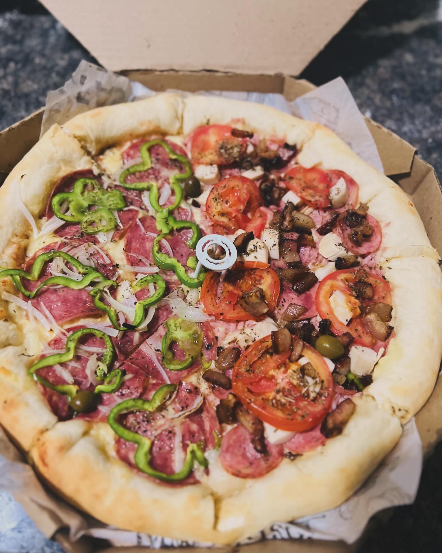Pizza recheada com salame, tomate, pimentão, azeitona e queijo