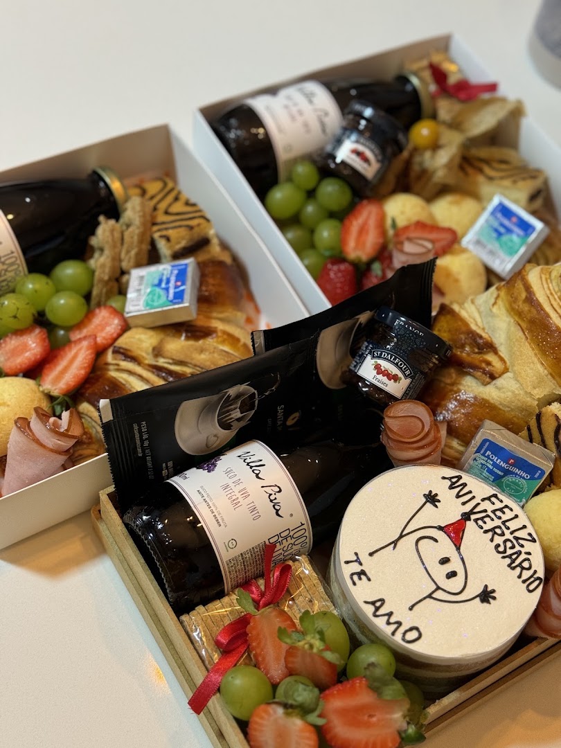 Caixa de presente com espumante, morangos e doces e um selo escrito Te Amo