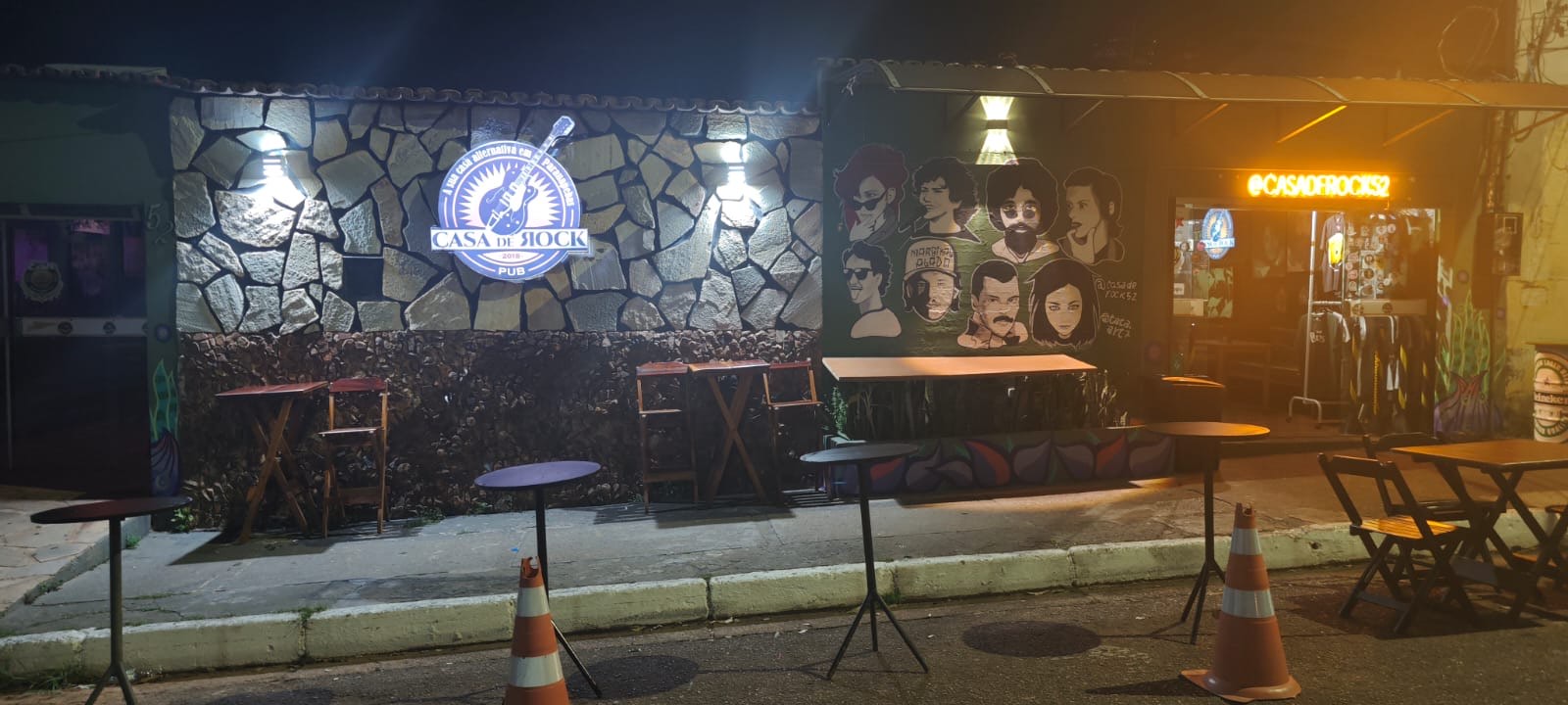 Salão da Casa de Rock com palco e parede de pedra