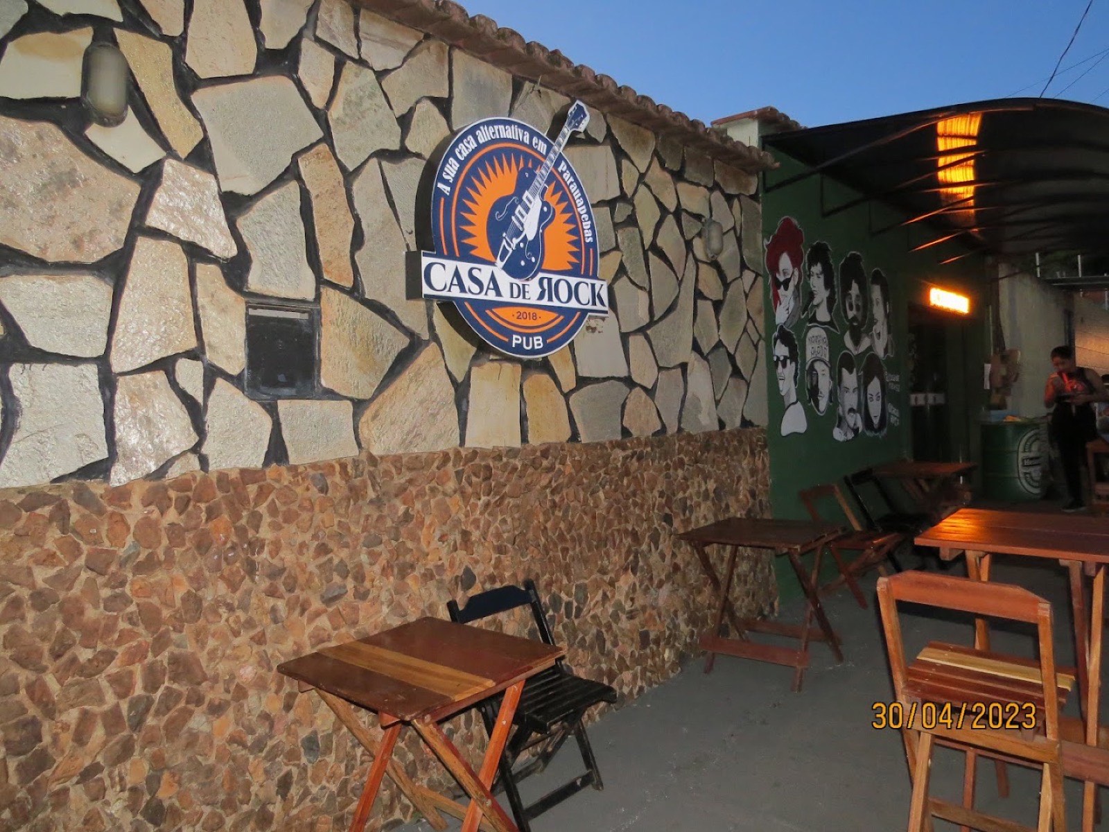 Fachada da Casa de Rock com parede de pedra