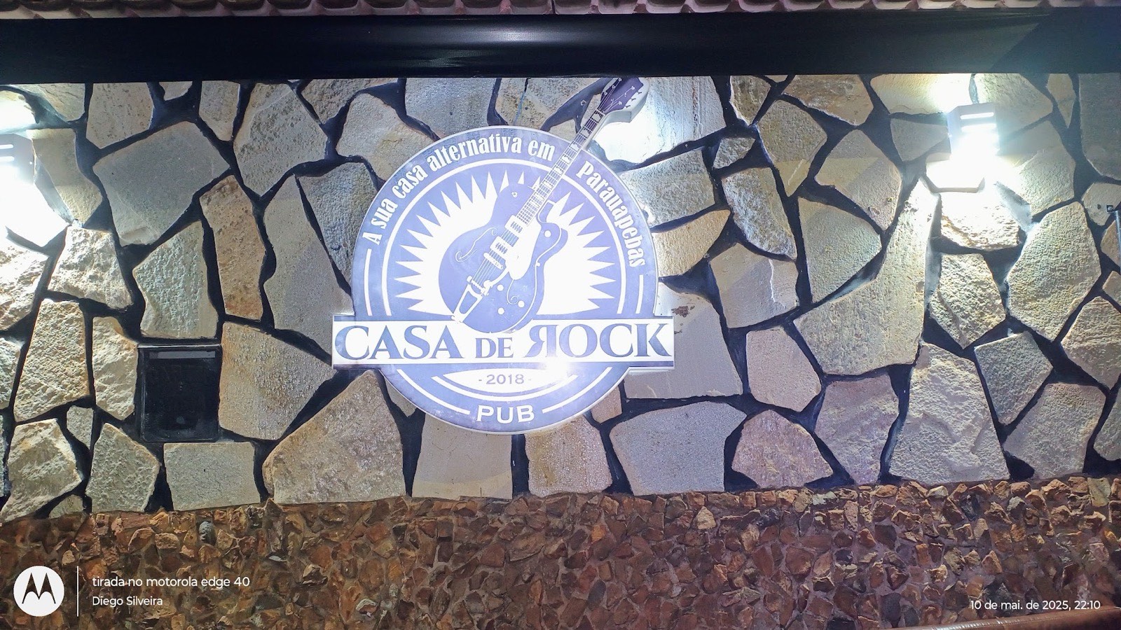 Parede de pedra com o logo da Casa de Rock