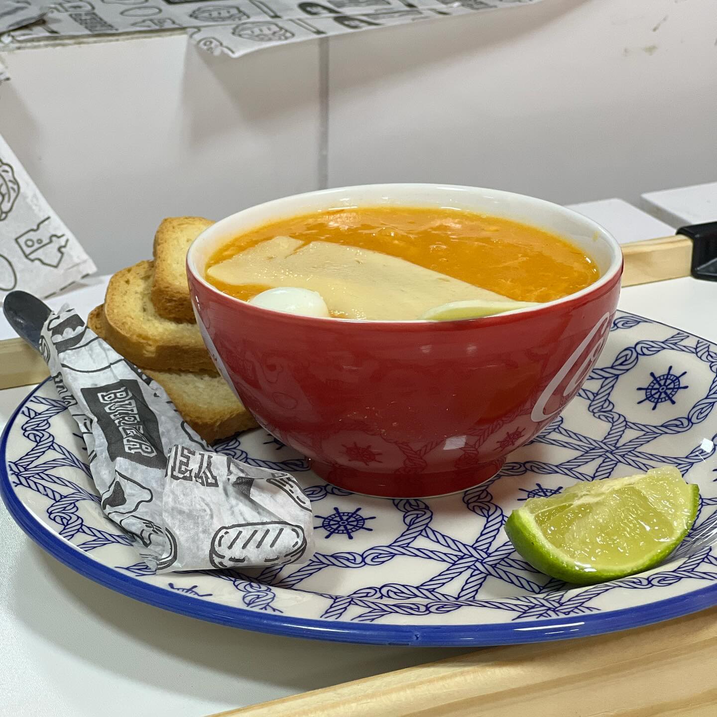 Caldo quente com queijo, ovo e torrada servido com limão