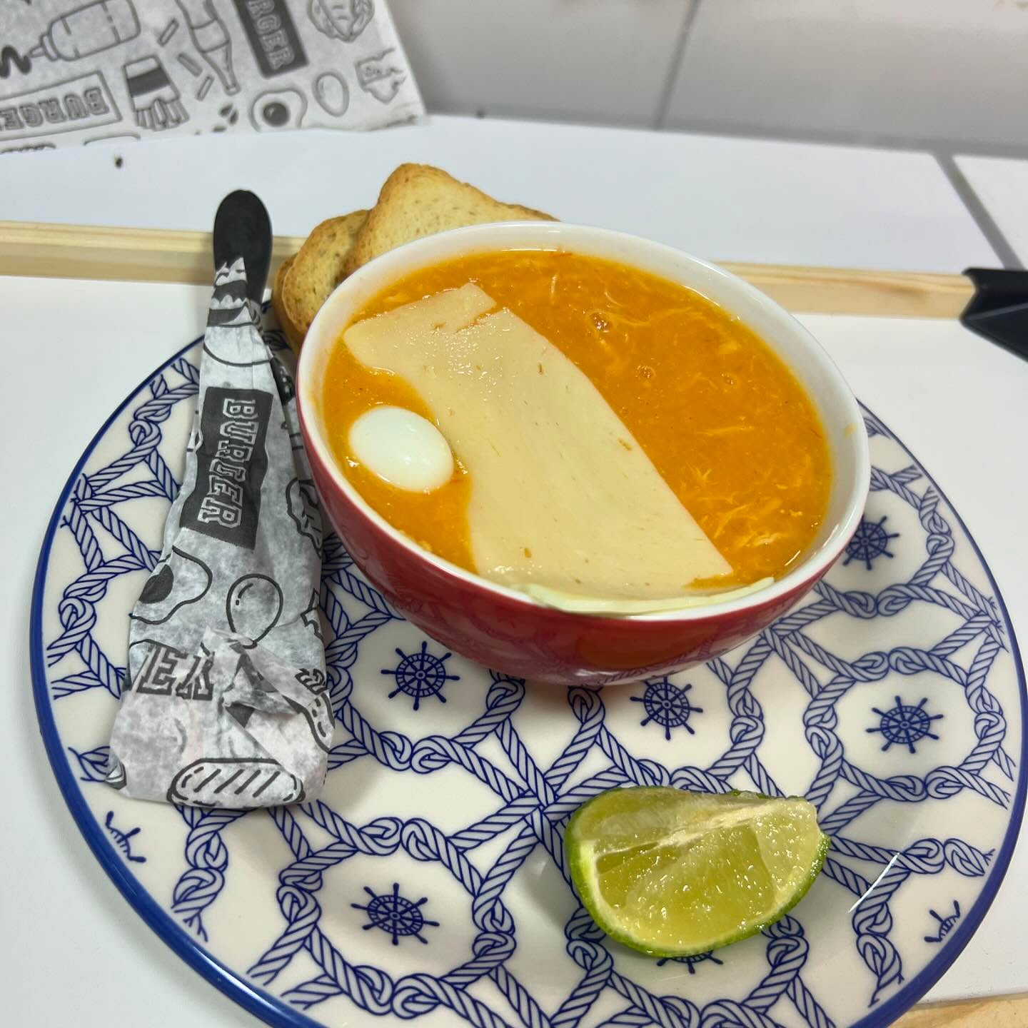Caldo encorpado com fatia de queijo e torradas