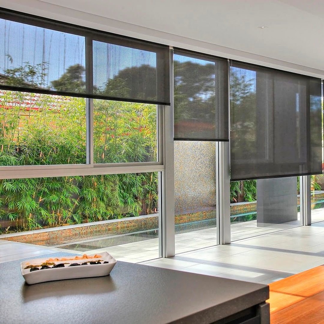 Sala ampla com persiana rolô e vista para o jardim