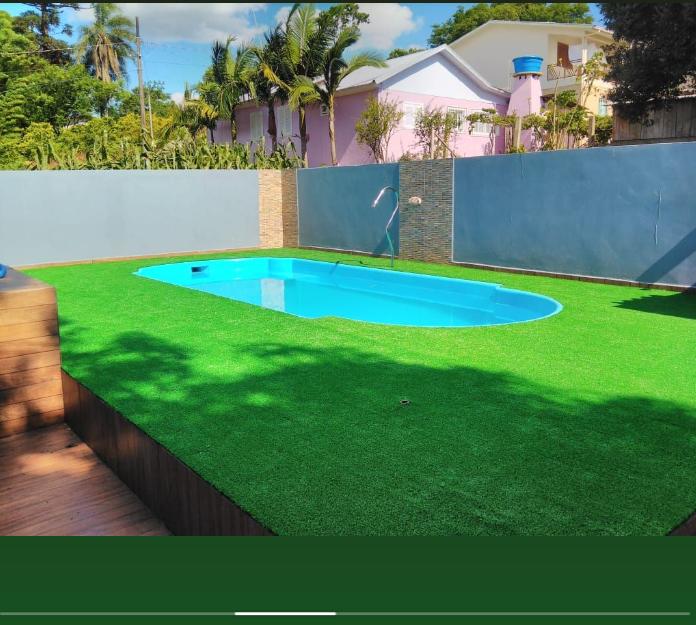 Quintal com grama sintética ao redor da piscina