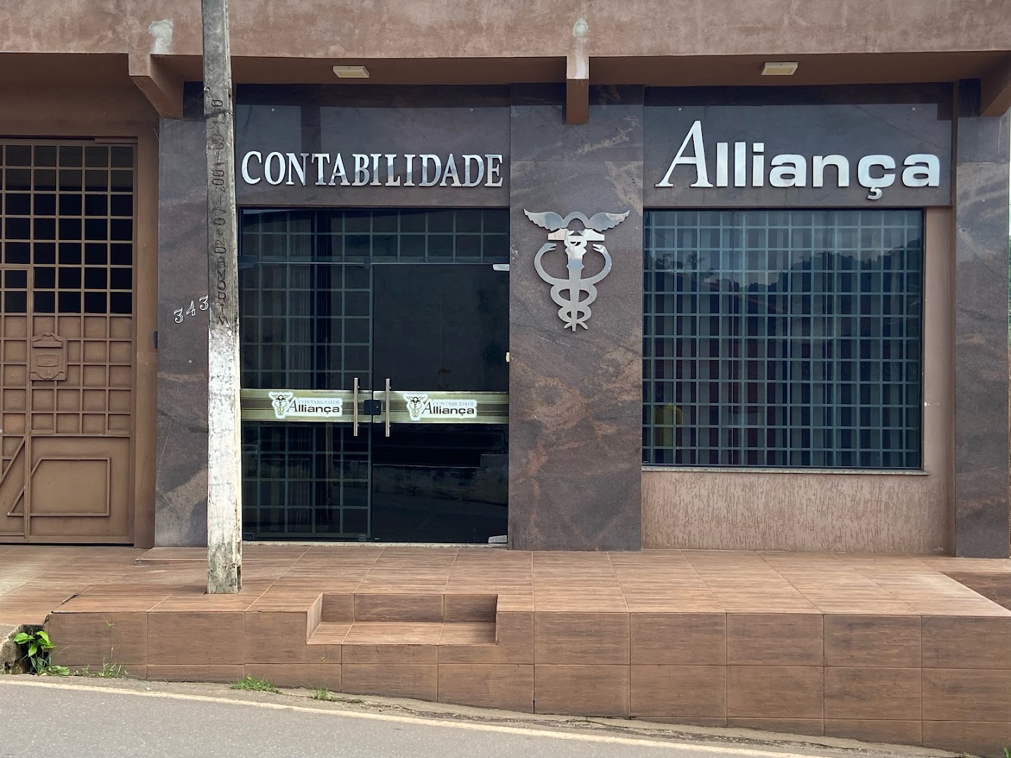 Letreiro Contabilidade Alliança na fachada de pedra escura