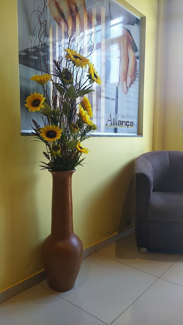 Recepção da Contabilidade Alliança, vaso de girassóis e quadro com a logo