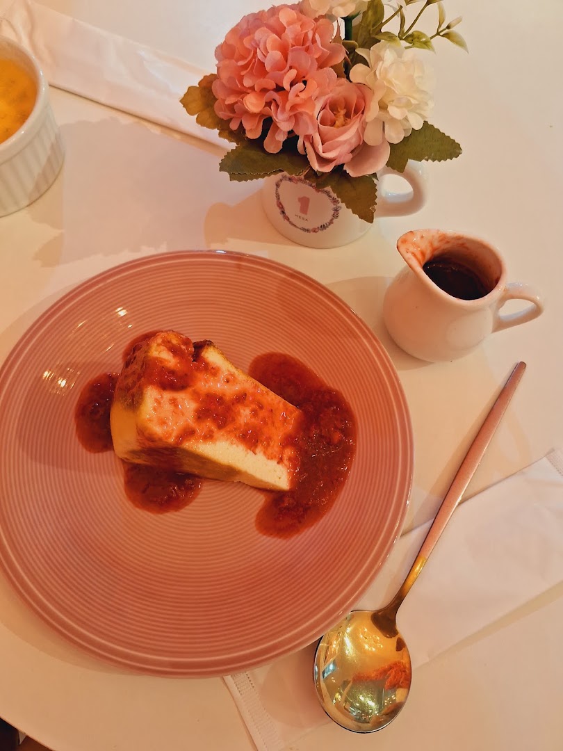 Cheesecake com calda vermelha, acompanhado de um café