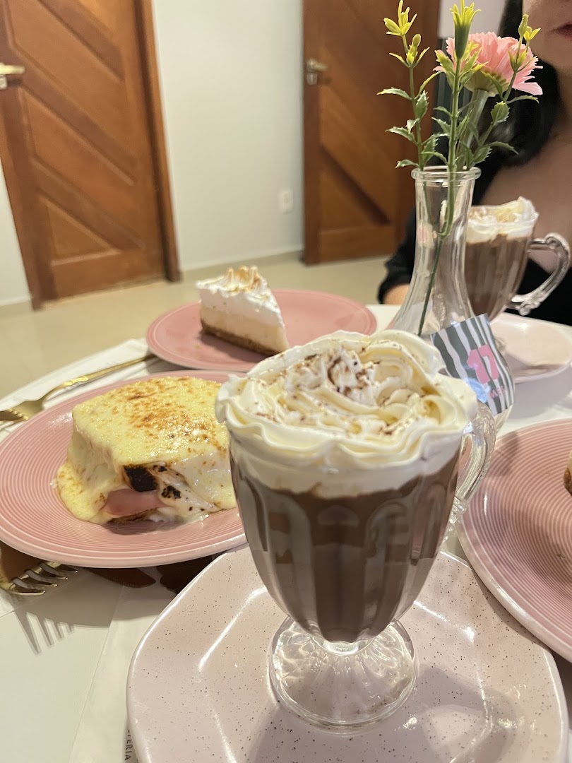 Mesa com uma fatia de doce e um café com creme