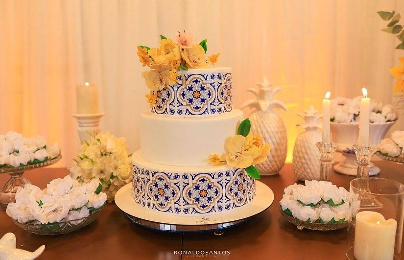 Bolo de dois andares com faixas em azul e branco e flores
