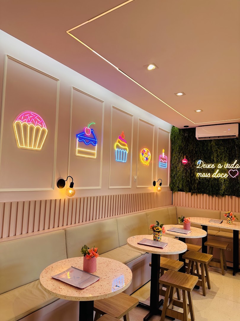 Salão aconchegante com letreiro em neon e mesinhas rosa