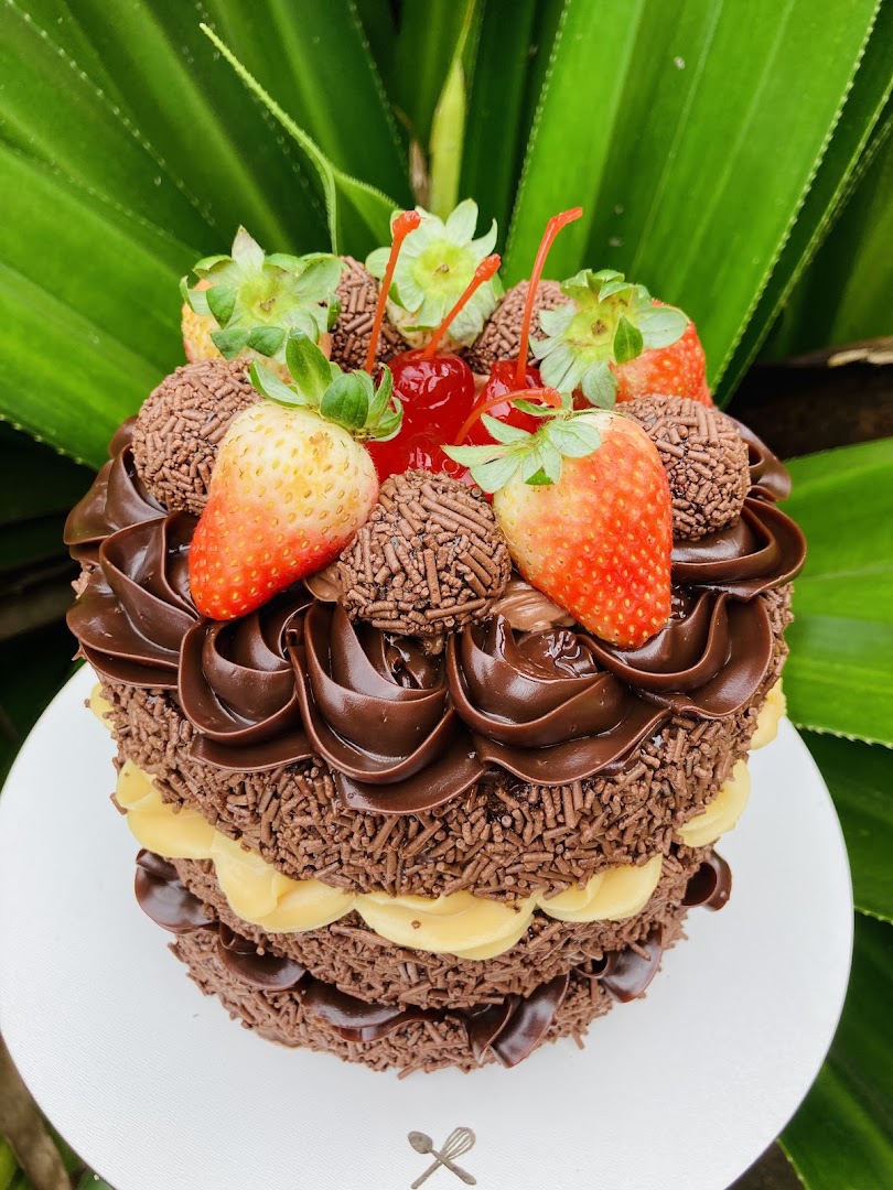 Bolo alto de chocolate coberto de brigadeiro, com morangos e cerejas