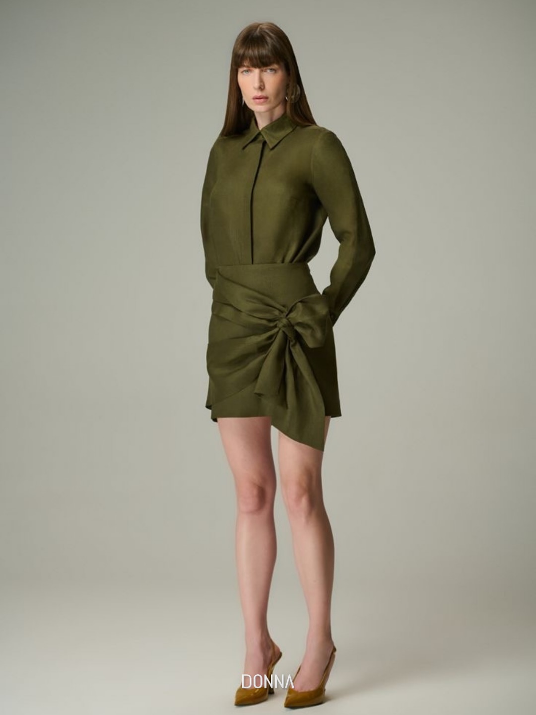 Modelo em chemise verde militar com saia de amarração, em estúdio