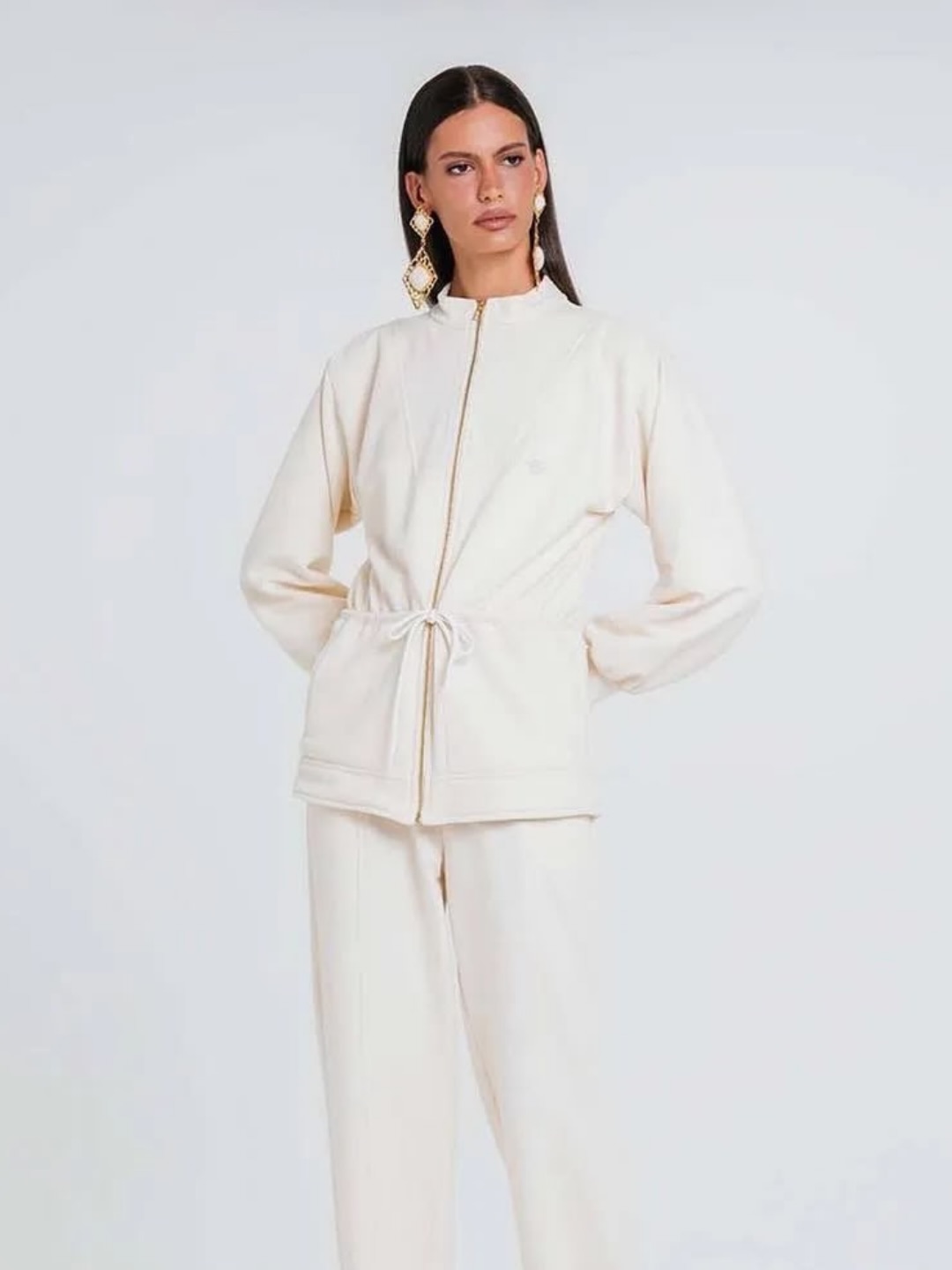 Modelo em conjunto off white de jaqueta com cord&atilde;o e cal&ccedil;a, em est&uacute;dio