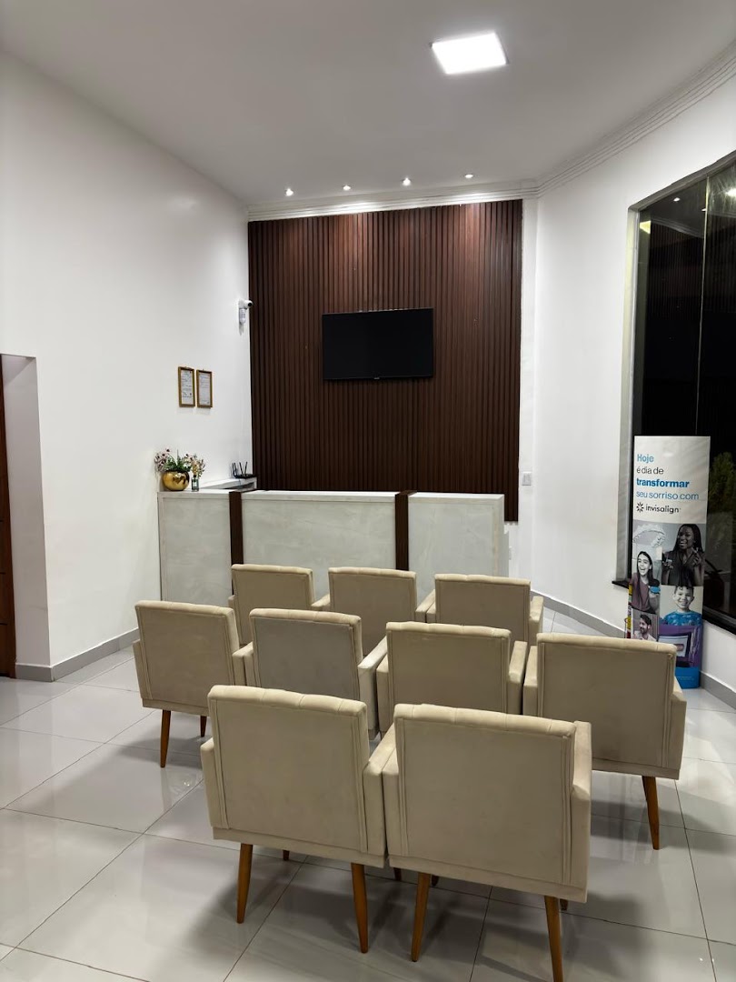 Recepção da Clínica Doutor Sorriso com poltronas creme