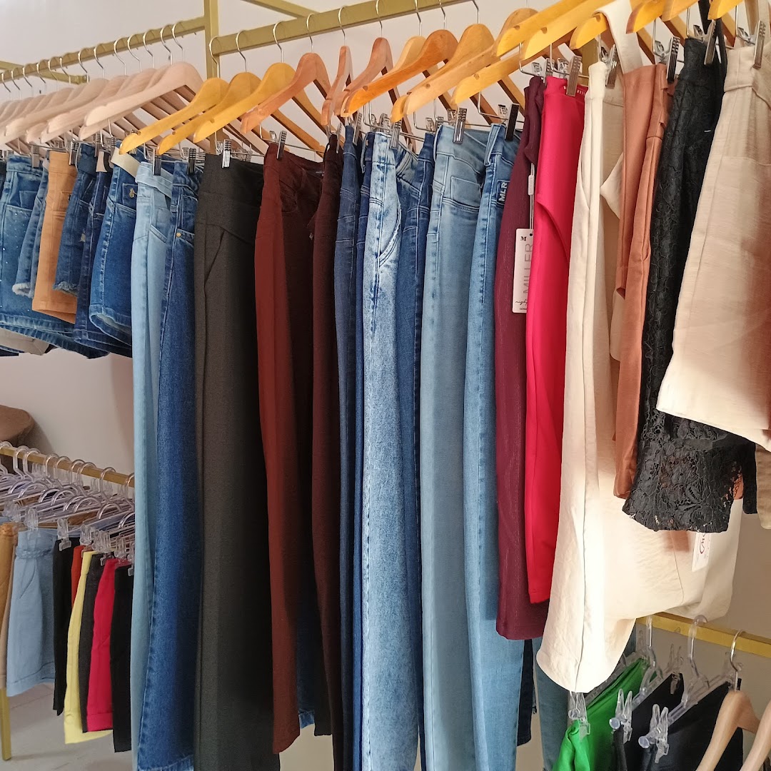Jeans e calças pendurados em cabides de madeira