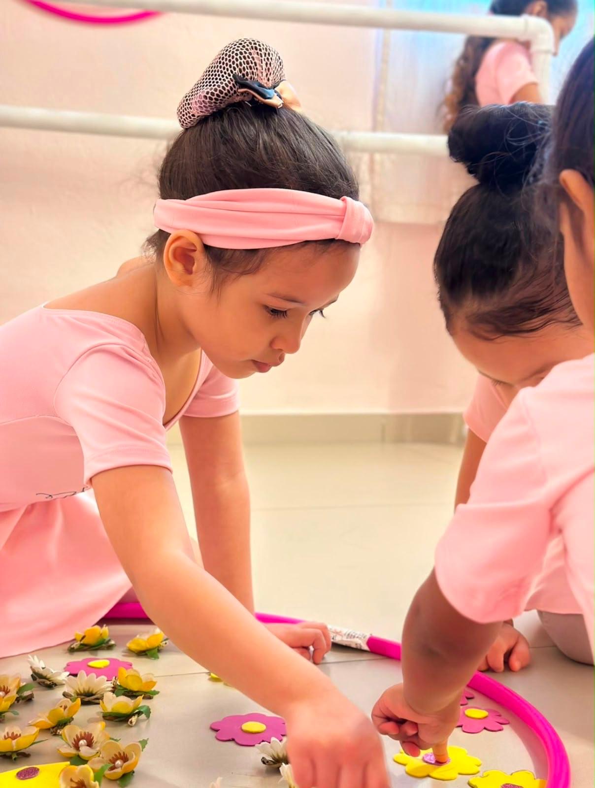 Bailarinas concentradas numa atividade com flores
