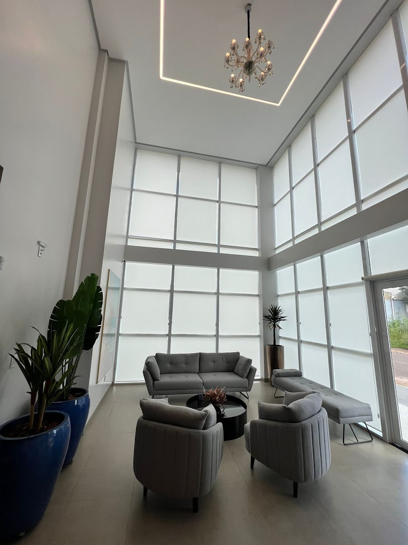 Lobby de pé-direito duplo com plantas e poltronas