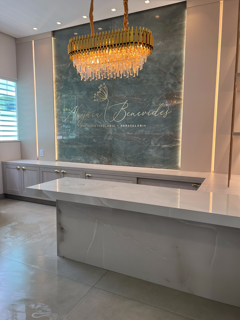 Balcão de recepção em mármore com lustre dourado