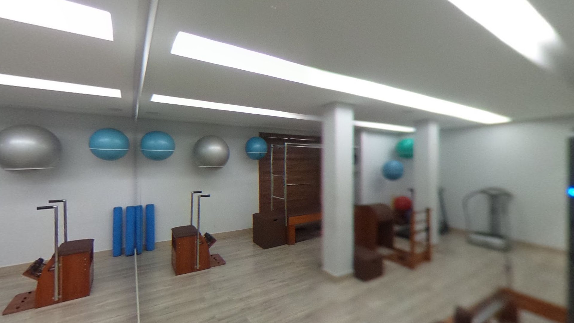 Estúdio de pilates da Essencial, com aparelhos de madeira e bolas