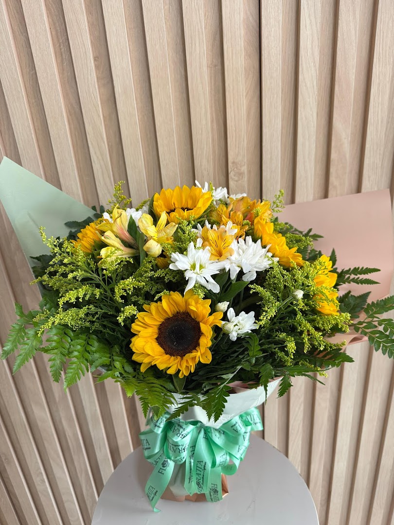 Buquê de girassóis com flores brancas e fita verde da Floratta
