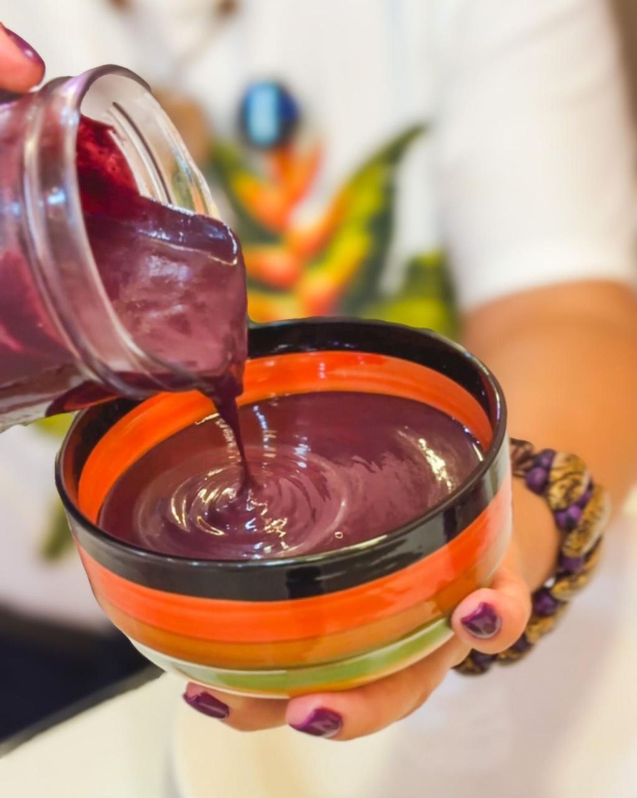 Açaí cremoso sendo servido na tigela colorida