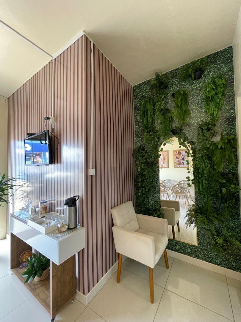 Espaço de estar com parede verde de plantas e poltrona