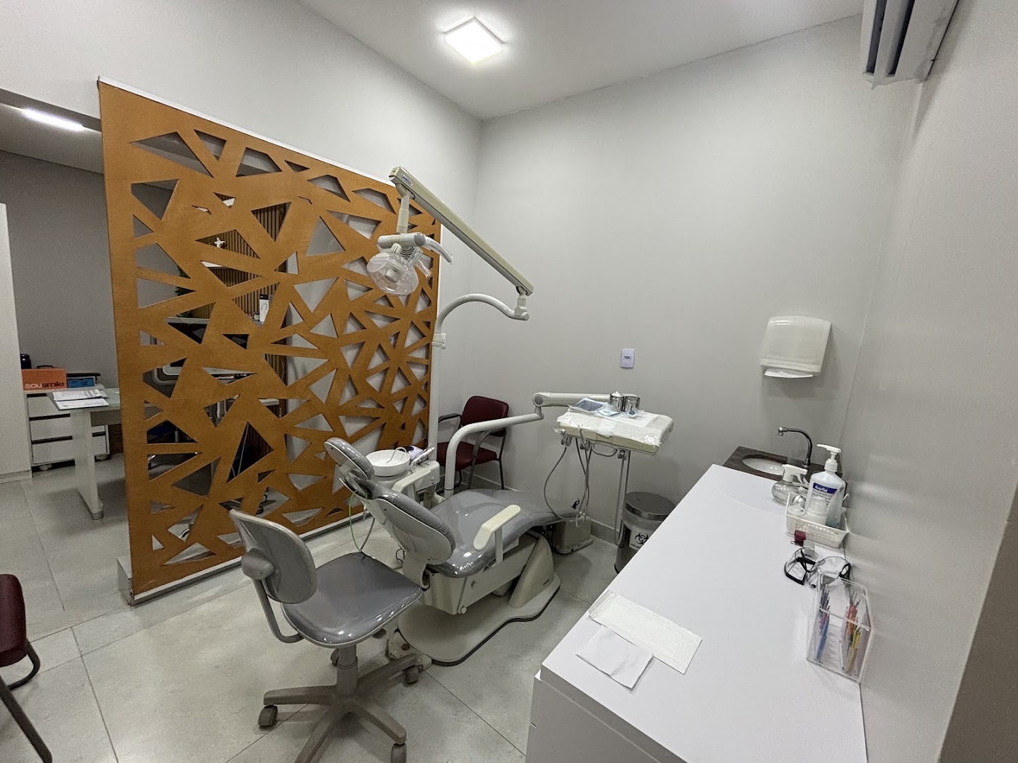 Consultório odontológico moderno com cadeira e painel decorativo
