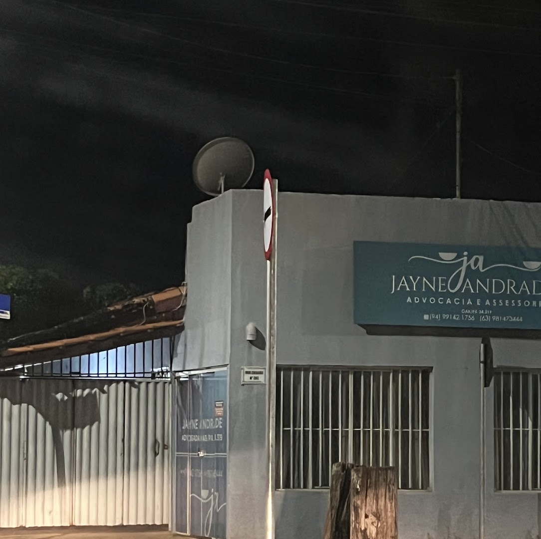 Fachada do escritório com a placa iluminada, à noite