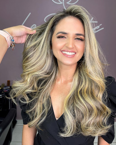 Cliente com cabelo loiro iluminado, mechas e finalização feita no La Beauté